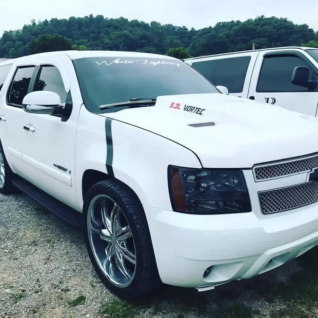 Custom 2007 Chevy Tahoe build finished in white with twin racing stripes and 24-inch chrome wheels