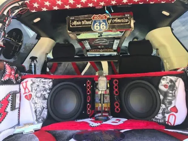 Custom rear cargo build with twin subwoofers in a hand-upholstered red, white and black enclosure
