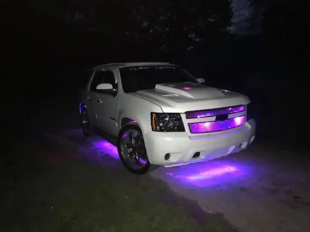 Custom Tahoe at night with purple underglow and grille lighting