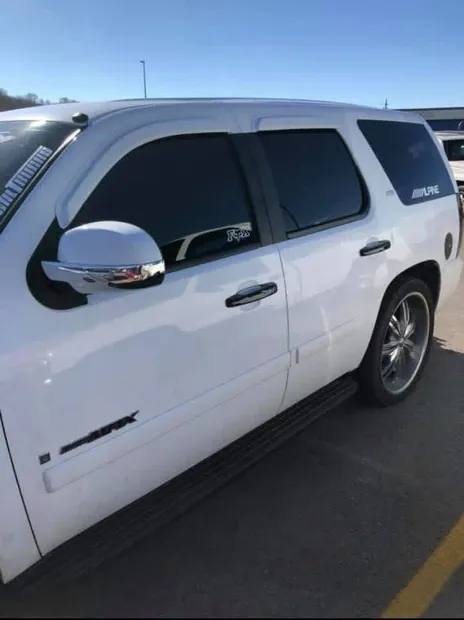 Side profile of the finished custom Tahoe with chrome mirror caps and window visors